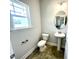 Stylish powder room with a pedestal sink, round mirror, updated fixtures, and a comfort height toilet at 203 Lake Edge Dr, Lillington, NC 27546