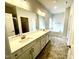 Bathroom with double sink vanity, large mirror and tub in neutral color palette at 217 Lake Edge Dr, Lillington, NC 27546