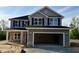 Two-story home featuring stone accents, an attached two-car garage, black shutters and a covered porch at 217 Lake Edge Dr, Lillington, NC 27546