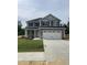 Two story home featuring a two car garage, stone accents, manicured lawn and charming curb appeal at 217 Lake Edge Dr, Lillington, NC 27546