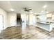 Open-concept living room featuring hardwood floors, a ceiling fan, and views of the kitchen and staircase at 217 Lake Edge Dr, Lillington, NC 27546