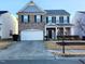Two-story brick home with gray siding, two-car garage, and landscaping at 302 Glenview Ln, Durham, NC 27703