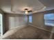 Spacious main bedroom with carpet, ceiling fan, and two windows at 302 Glenview Ln, Durham, NC 27703