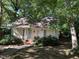 Front view of a yellow cottage with a brick walkway and lush landscaping at 322 Mccauley St, Chapel Hill, NC 27516