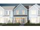 Two-story townhome with gray siding, brick accents, and landscaping at 365 Fosterton Cottage Way, Raleigh, NC 27603