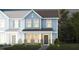 Two-story townhome with light blue siding, brick accents, and landscaping at 371 Fosterton Cottage Way, Raleigh, NC 27603