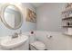 Small bathroom with pedestal sink, toilet and decorative wall art at 516 Argyll Dr, Sanford, NC 27332