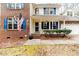 Brick front porch with blue shutters and American flag at 516 Argyll Dr, Sanford, NC 27332