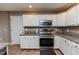 Kitchen boasts white cabinets, granite countertops, and stainless steel appliances at 516 Argyll Dr, Sanford, NC 27332