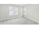 Bright bedroom with grey carpet and two large windows at 5734 Corbon Crest Ln, Raleigh, NC 27612