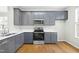Gray cabinets, quartz countertops and stainless steel appliances in this kitchen at 5734 Corbon Crest Ln, Raleigh, NC 27612