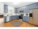 Modern kitchen with gray cabinets, stainless steel appliances, and breakfast bar at 5734 Corbon Crest Ln, Raleigh, NC 27612