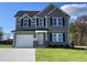 Two-story house with gray siding, white garage door, and landscaping at 59 Holly Grove Ln, Lillington, NC 27546