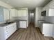 Modern kitchen featuring white cabinets, granite countertops, and LVP flooring at 59 Holly Grove Ln, Lillington, NC 27546
