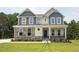 Two-story home with stone and siding accents, featuring a welcoming front porch at 72 Demascus Way, Four Oaks, NC 27524