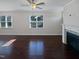 Bright living room featuring hardwood floors, fireplace, and large windows at 917 Palm Ct, Mebane, NC 27302