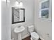 Powder room with pedestal sink and dark framed mirror at 917 Palm Ct, Mebane, NC 27302