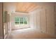 Bright bedroom featuring a stylish wood-paneled ceiling, wainscotting, and large windows at 1116 Delilia Ln, Wake Forest, NC 27587