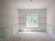 A bright, empty bedroom featuring wainscotting and a large window at 1116 Delilia Ln, Wake Forest, NC 27587