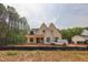 An exterior view of a two-story home with a white facade and black trim, set in a partially cleared lot at 1116 Delilia Ln, Wake Forest, NC 27587