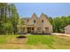 An exterior shot of a beautifully designed home with a lush green lawn and wooded surroundings at 1116 Delilia Ln, Wake Forest, NC 27587
