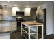 Modern kitchen with stainless steel appliances, granite counters, and a functional center island at 1312 Fay St, Durham, NC 27701