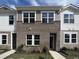 Two-story townhome with brick and siding exterior, featuring multiple windows and a front yard at 2054 Glen Crossing Dr, Durham, NC 27704