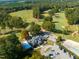 Aerial view of a golf course with mature trees and a clubhouse surrounded by a parking lot at 2662 Sledge Rd, Louisburg, NC 27549