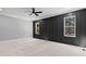 Bedroom with modern black accent wall, carpeted flooring, and natural light from two large windows at 2662 Sledge Rd, Louisburg, NC 27549