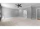 Spacious bedroom featuring carpet, neutral gray walls, a ceiling fan, and an ensuite bath at 2662 Sledge Rd, Louisburg, NC 27549