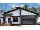 Contemporary home with modern architecture, dark window frames, and gray garage door at 2662 Sledge Rd, Louisburg, NC 27549