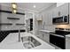 Charming kitchen boasts gray cabinets, quartz countertops, stainless appliances and custom shelving at 2662 Sledge Rd, Louisburg, NC 27549