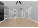 Open-concept living room showing a kitchen area off of the modern fireplace and custom shelving unit at 2662 Sledge Rd, Louisburg, NC 27549