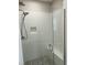 Bathroom shower with white subway tile, rain shower head, recessed shelf, seating, and glass door at 318 Hinton St, Apex, NC 27502