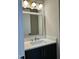 Bathroom featuring a white countertop, black vanity, gold hardware, and decorative lighting at 318 Hinton St, Apex, NC 27502