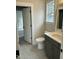 Bathroom featuring gray vanity, white countertop, toilet, gray tile floors, and large window at 318 Hinton St, Apex, NC 27502
