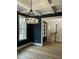 Dining room featuring a coffered ceiling, modern chandelier, dark gray walls, and hardwood floors at 318 Hinton St, Apex, NC 27502