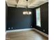 Dining room featuring a coffered ceiling, modern chandelier, dark gray walls, and hardwood floors at 318 Hinton St, Apex, NC 27502