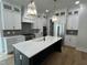 Modern kitchen featuring white cabinetry, stainless steel appliances, a large island, and hardwood floors at 318 Hinton St, Apex, NC 27502
