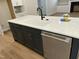 Spacious kitchen island features a sink, dishwasher, and plentiful storage in this stylish design at 318 Hinton St, Apex, NC 27502