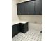 Laundry room featuring decorative gray patterned floors, gray cabinets, and white countertops at 318 Hinton St, Apex, NC 27502