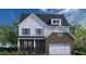 Two-story home with brick and white siding, a two-car garage, and landscaping at 3209 Armeria Dr, Apex, NC 27502
