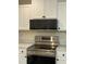Stainless steel oven range with above range microwave and black hardware at 3928 Mike Levi Ct, Raleigh, NC 27610