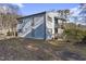 Light blue multi-level home with deck and surrounding trees at 5112 Flint Ridge Pl, Raleigh, NC 27609