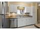 White kitchen cabinets, stainless steel dishwasher, and double sink at 5112 Flint Ridge Pl, Raleigh, NC 27609