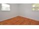 Well-lit bedroom featuring hardwood floors and two windows at 5617 Laurel Crest Dr, Durham, NC 27712