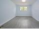Light-filled bedroom with gray tile floors and two windows at 5617 Laurel Crest Dr, Durham, NC 27712