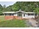 Brick and white ranch home with a large window and landscaped yard at 5617 Laurel Crest Dr, Durham, NC 27712