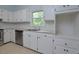 White kitchen cabinets, stainless steel dishwasher and double sink at 5617 Laurel Crest Dr, Durham, NC 27712