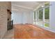 Living room with hardwood floors, brick fireplace, and large windows at 5617 Laurel Crest Dr, Durham, NC 27712
